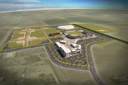 Aerial view of a large sports complex featuring multiple fields, a stadium, and surrounding parking areas.