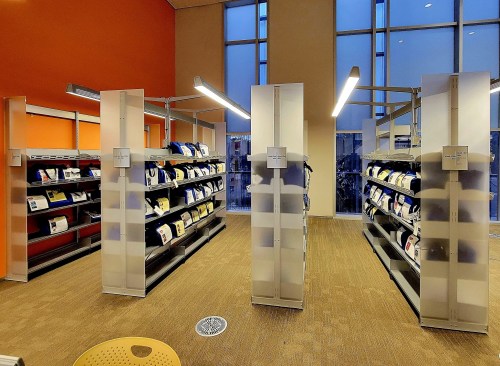 A modern library interior featuring shelves filled with books and a bright, spacious atmosphere.