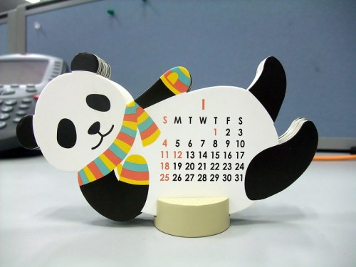 A cute panda-shaped desk calendar with colorful scarf, displaying the month of January and its dates.
