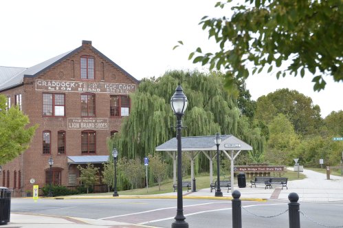 Historic brick building with "Craddock-Terry" signage, surrounded by trees and a nearby bus stop.