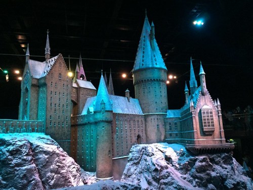 A detailed model of a castle with towers and snowy surroundings, illuminated by blue lights.
