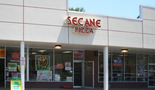 Exterior of Secane Pizza shop with bright signage and open windows, featuring a lottery sign nearby.