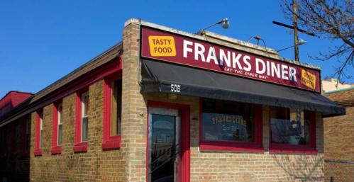 Exterior of Frank's Diner, featuring a brick facade and a red awning with the text "Tasty Food" and "Eat the Diner Way."