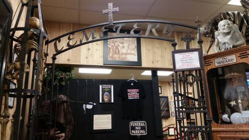 Entrance to a themed cemetery display featuring skeletons, crosses, and a "Funeral No Parking" sign.