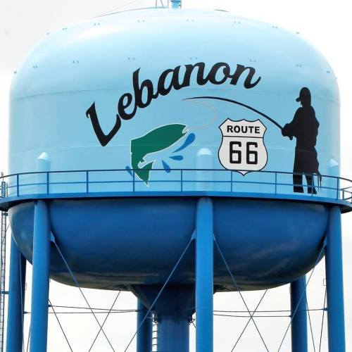 A blue water tower with "Lebanon" and a silhouette of a fisherman, featuring a Route 66 sign.