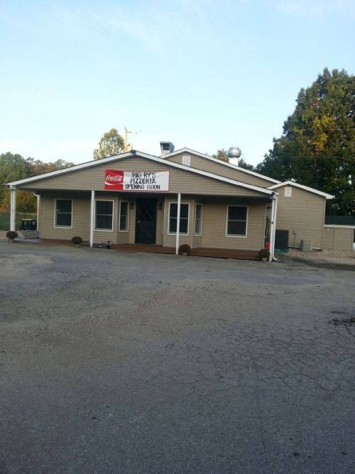 A single-story building with a sign for a restaurant, featuring a Coca-Cola logo and a welcoming entrance.