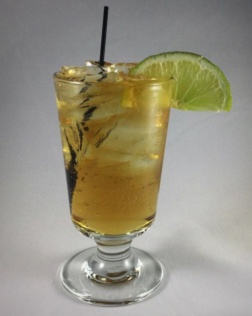 A refreshing cocktail in a glass with ice, garnished with a lime slice and a black straw.