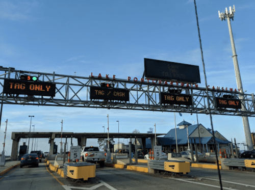 Toll booth with electronic signs displaying payment options: "Tag Only" and "Tag/Cash" at Lake Pontchartrain Causeway.