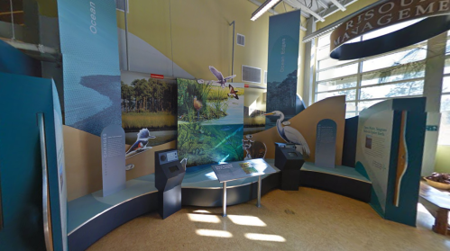 Exhibit space featuring informational displays about ocean and coastal management, with interactive screens and visuals.