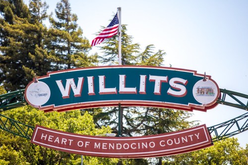 Sign for Willits, California, featuring "Heart of Mendocino County" and an American flag above. Green and red colors.