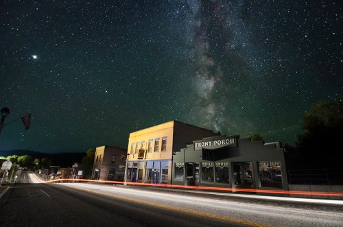 A quiet street scene at night with a starry sky and the Milky Way above a building labeled "Front Porch."