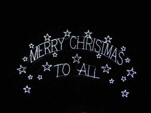 A festive display of lights spelling "Merry Christmas to All" with stars against a dark background.