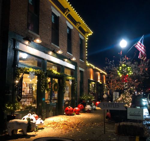 A charming vintage shop decorated with lights and autumn decor, featuring pumpkins and festive greenery at night.