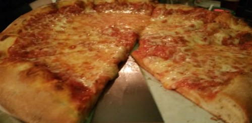 A close-up of a cheese pizza with a few slices removed, showcasing a golden crust and melted cheese.