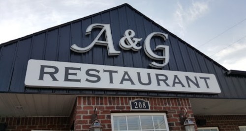Sign for A&G Restaurant, featuring a black and white design with a brick facade. Address: 208.