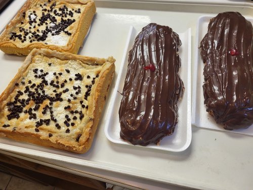 A tray with two chocolate-covered pastries and a square dessert topped with chocolate chips.