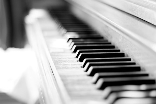Close-up of piano keys in black and white, showcasing their texture and depth.