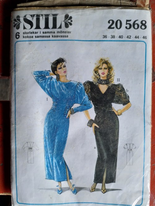 Fashion pattern cover featuring two women in elegant dresses: one in blue and one in black, showcasing different styles.