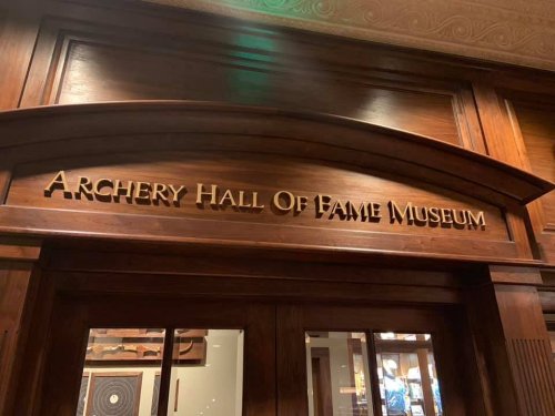 Sign above the entrance to the Archery Hall of Fame Museum, featuring wooden details and elegant lettering.