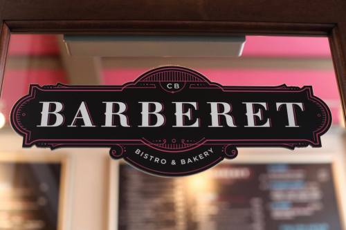 Sign for "Barberet Bistro & Bakery" displayed on a door, featuring elegant typography and a decorative border.