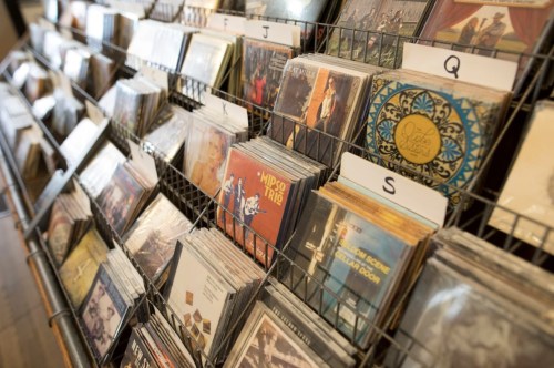 A display of various music CDs organized in a rack, labeled with letters for easy browsing.