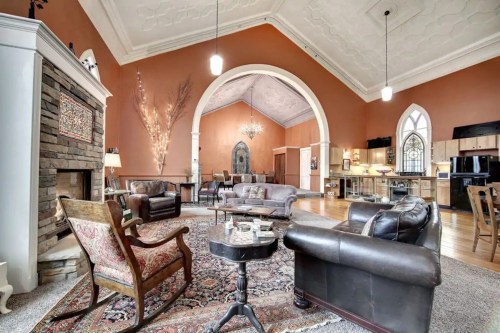Spacious living area with high ceilings, elegant decor, and a cozy seating arrangement around a central rug.