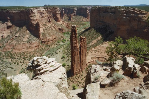 A stunning canyon landscape featuring towering rock formations and lush greenery below.