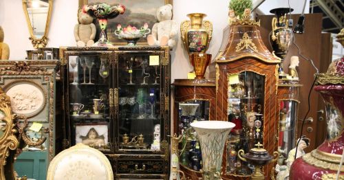 Close up of furniture, art, and glassware for sale at an antique shop similar to West End Antiques Mall in Richmond, Virginia