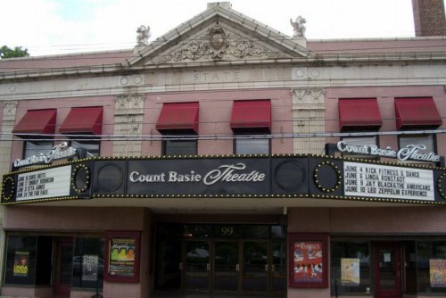 Exterior of the Count Basie Theatre, featuring a marquee with event listings and decorative architectural details.