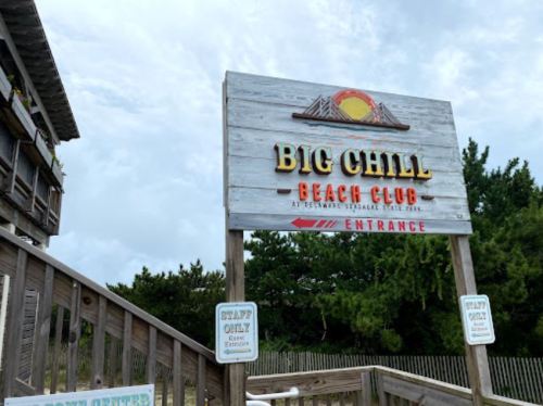 Sign for Big Chill Beach Club with wooden structure and greenery in the background, indicating the entrance.