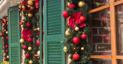 Windows decorated with garlands, flowers, and red and gold ornaments.