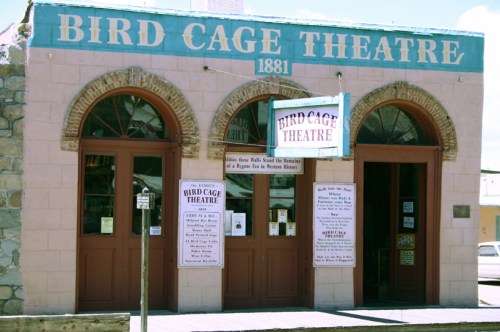 Historic Bird Cage Theatre building with arched windows and signage, showcasing its establishment in 1881.