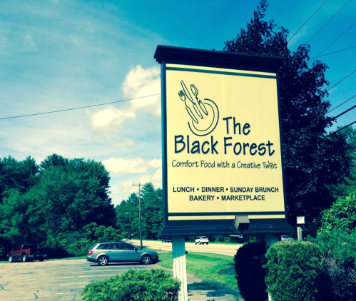 Sign for "The Black Forest" restaurant, featuring comfort food, with details about lunch, dinner, brunch, and a bakery.