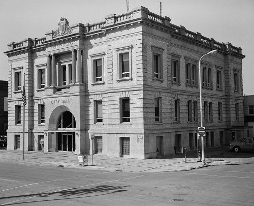 Historic city hall building with a grand facade, featuring large windows and decorative architectural details.