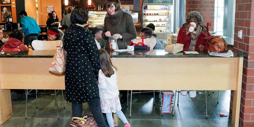 A busy café scene with people at a counter, a child with an adult, and others seated in the background.