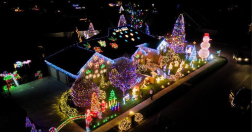 A beautifully decorated house with colorful Christmas lights, featuring trees, snowmen, and festive displays at night.
