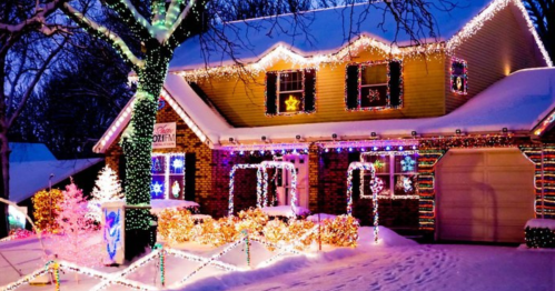 A beautifully decorated house with colorful Christmas lights and snow, creating a festive winter scene.