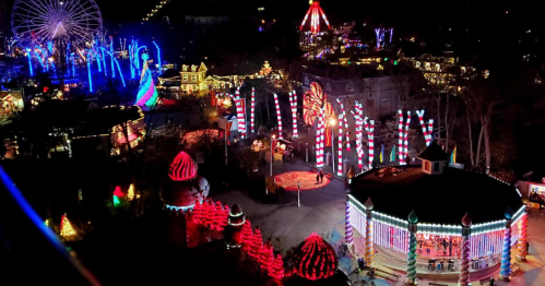 A vibrant amusement park at night, illuminated with colorful lights, featuring a Ferris wheel and festive decorations.
