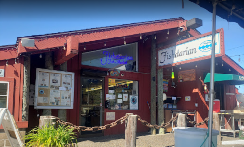 Exterior of a red building with signs for "Fishitarian" and "Fishdarian," featuring outdoor seating and a menu display.