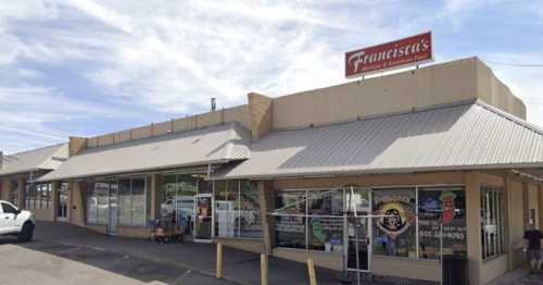 Exterior view of Francisca's restaurant, featuring a sign and a covered entrance, with a clear blue sky above.