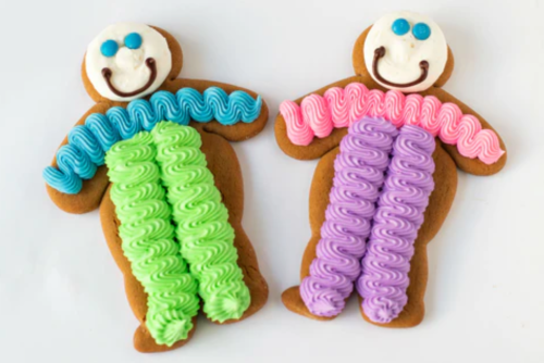 Two decorated gingerbread cookies shaped like people, with colorful icing for clothing and smiling faces.