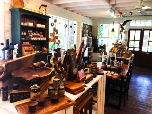A cozy shop interior filled with wooden kitchenware, jars, and decorative items, featuring a warm, inviting atmosphere.