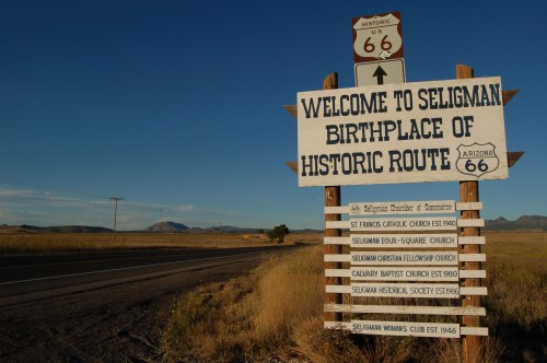 Sign welcoming visitors to Seligman, Arizona, birthplace of Historic Route 66, with directional information below.