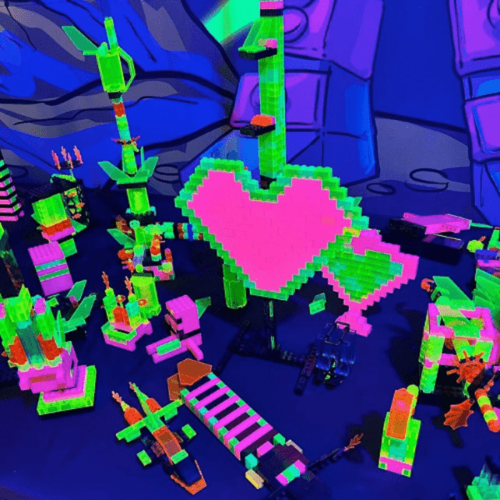 Colorful neon building blocks arranged in various shapes, including a large heart, against a vibrant background.