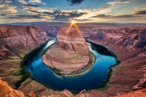 A stunning sunset over Horseshoe Bend, showcasing a winding river surrounded by red rock formations.