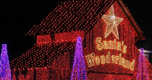 A festive display of red and purple lights on a building reading "Santa's Wonderland," topped with a star.
