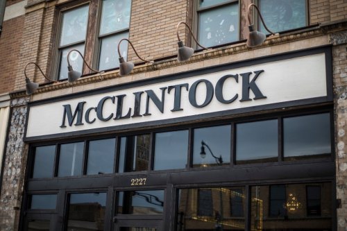 Sign for McClintock on a brick building, featuring large black letters above a glass entrance.