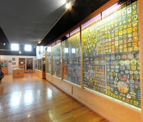 A museum interior featuring display cases filled with various badges and patches on the walls.