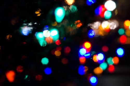 Colorful, blurred Christmas lights in various shapes and sizes, creating a festive, bokeh effect.