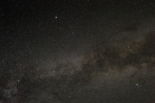 A starry night sky filled with countless stars and a faint band of the Milky Way galaxy.